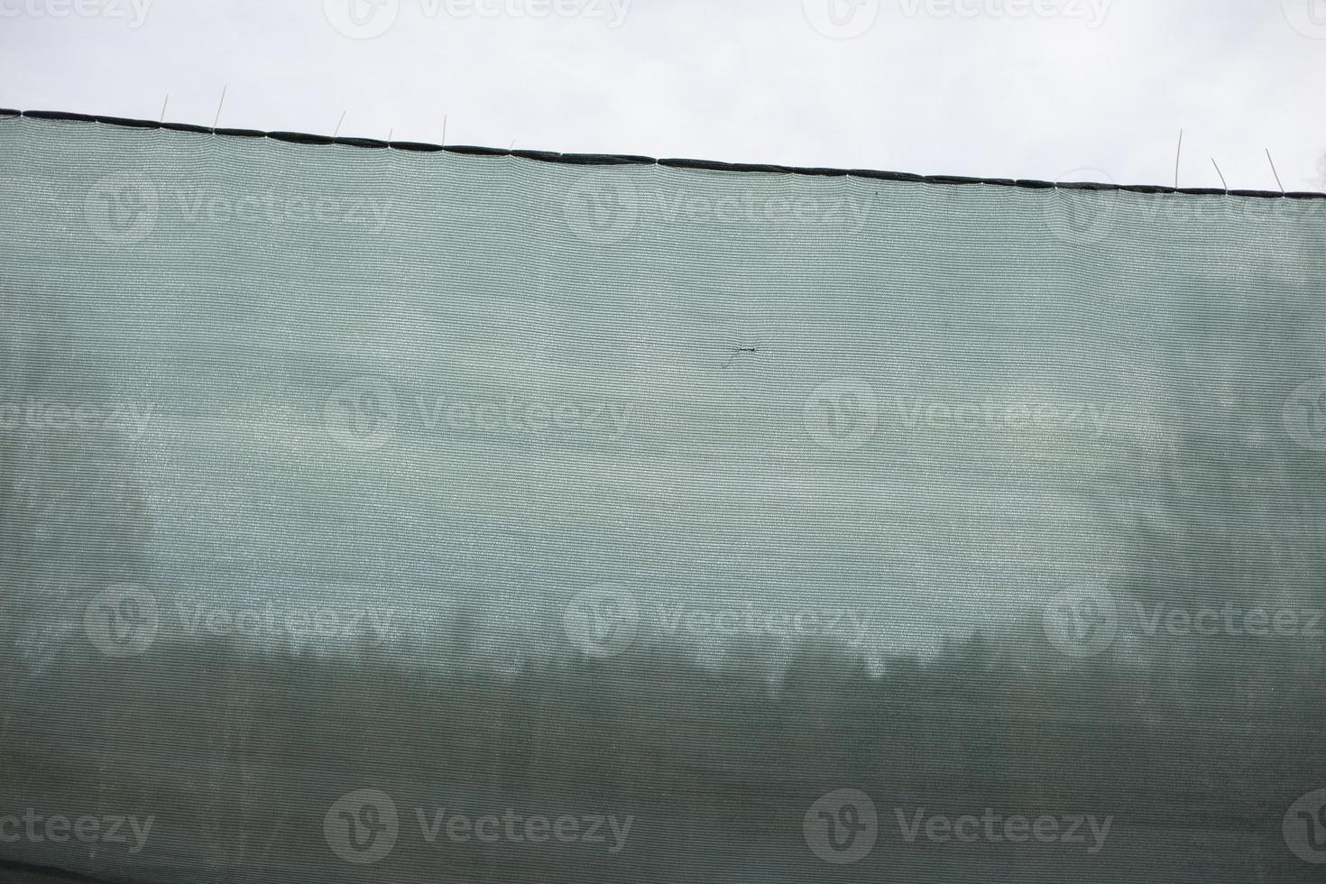 Green net on sports field. Play area for paint ball. photo