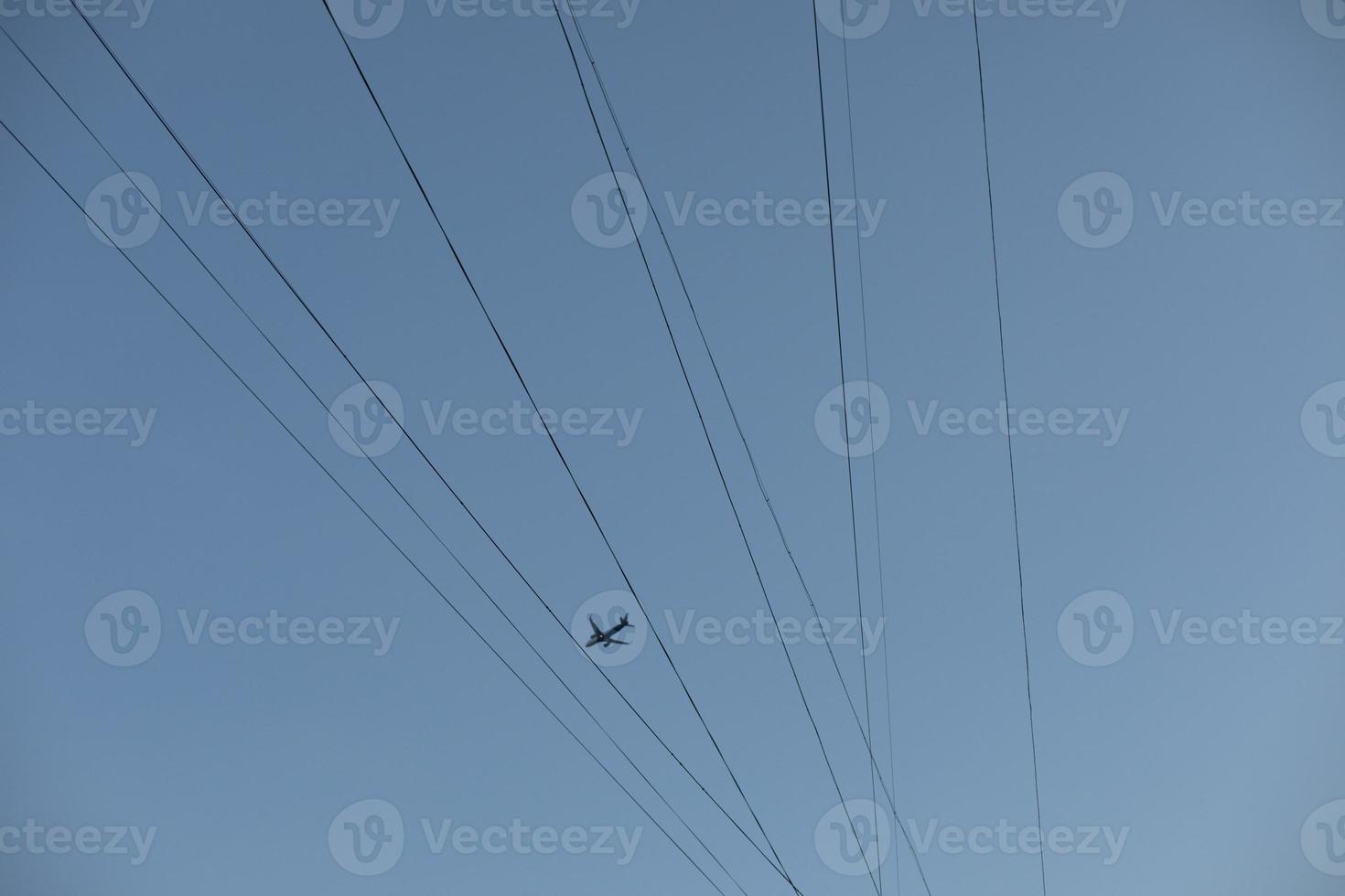 Wires in sky. Something flies across sky. photo
