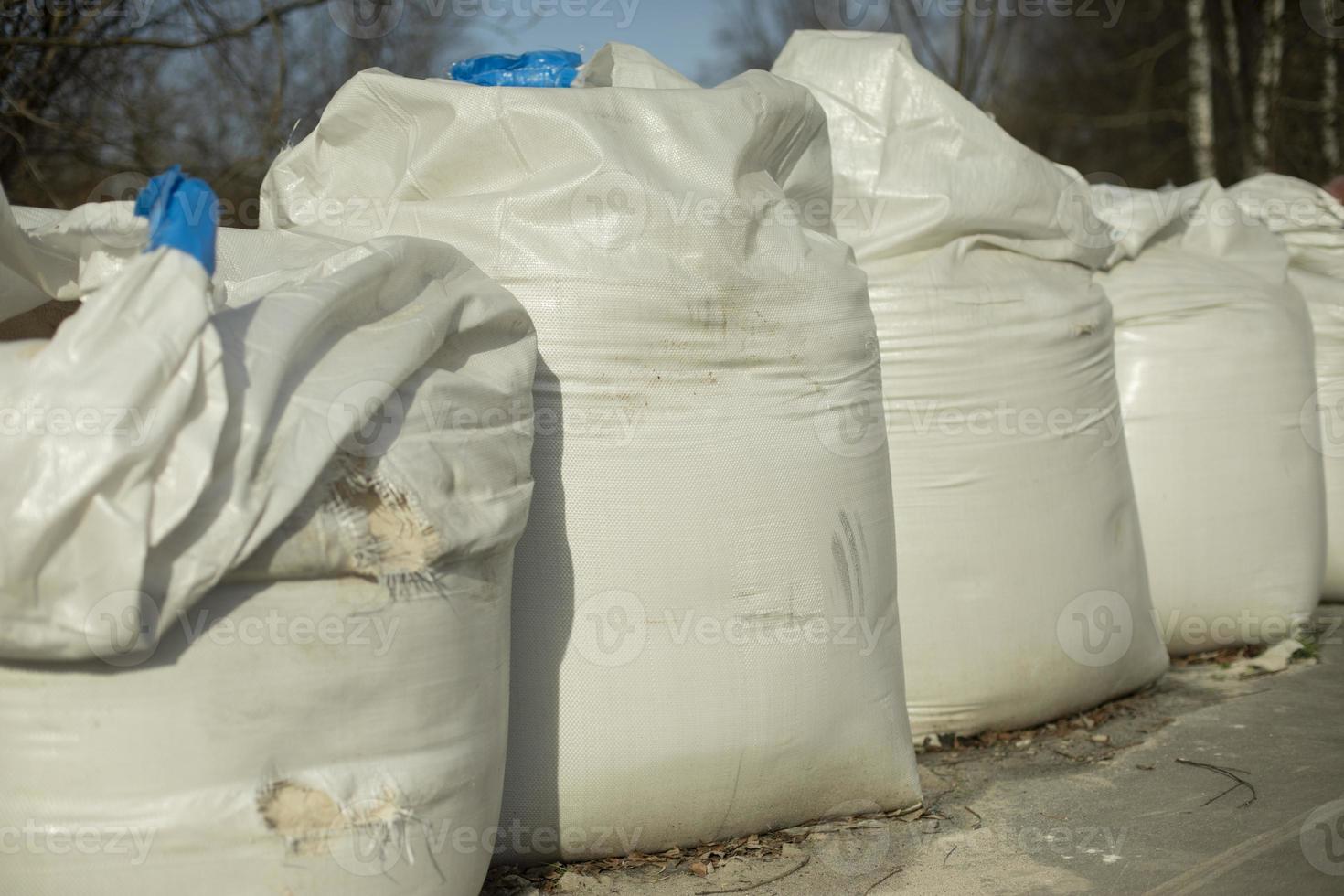 White sandbags. Large bags of material for construction. photo