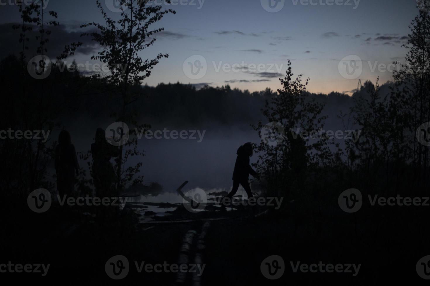 Man in fog on lake. Silhouette of man on shore. Outdoor recreation. photo