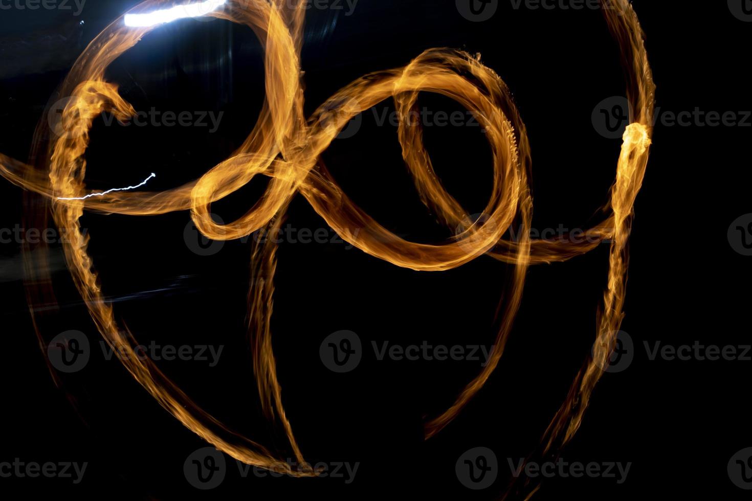 Chaotic lines of fire in dark. Movement of flames on black background. photo