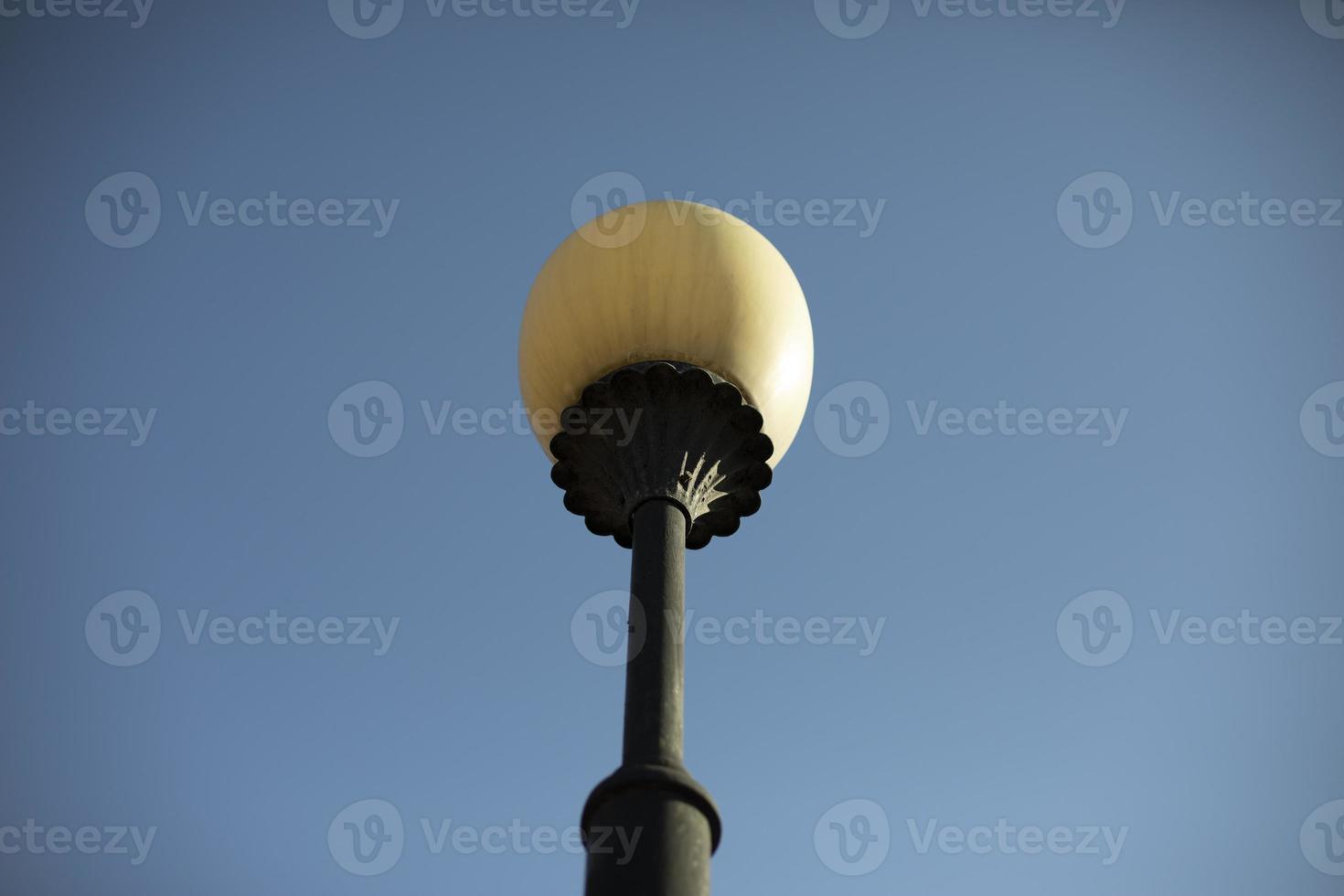 Pole with lamp in city. Ancient pillar. Urban light in 18th century. photo