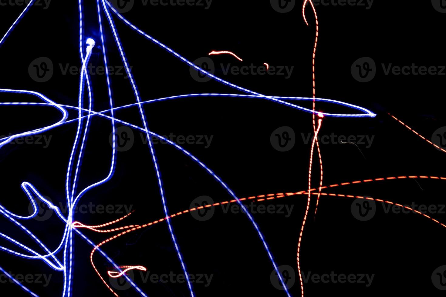 Chaotic lines in dark. Neon glow. Texture of bright lines. photo