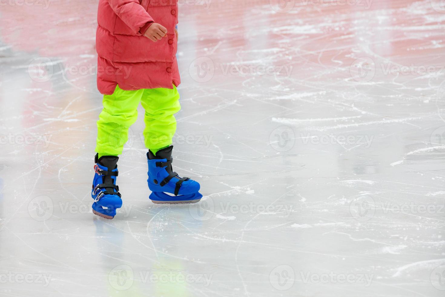 un adolescente con ropa brillante patina en un estadio de hielo. foto