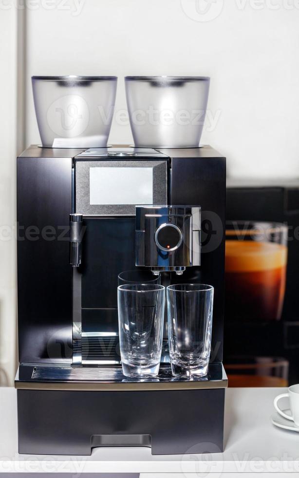 dos vasos de vidrio vacíos en el fondo de una máquina de café. foto