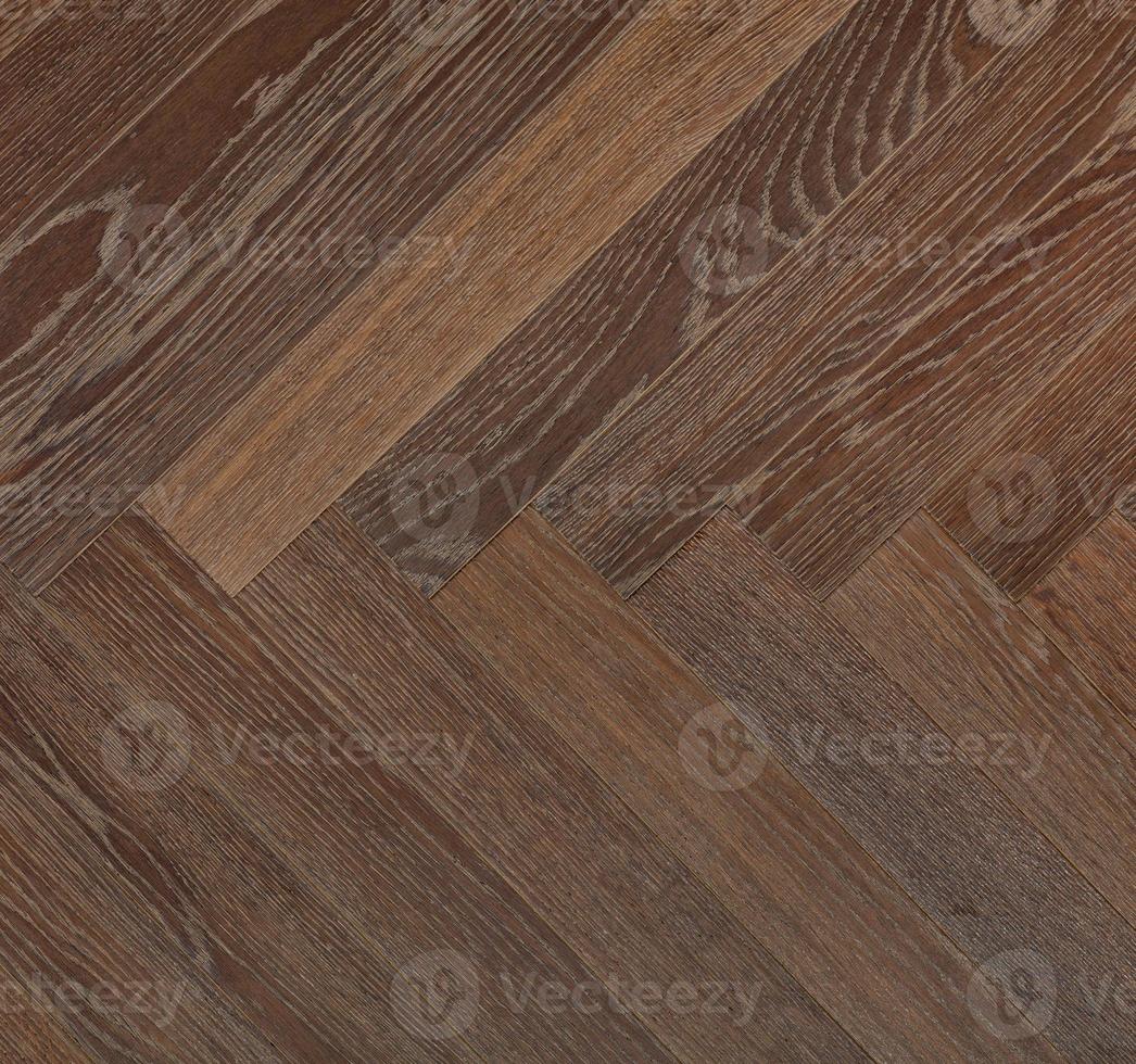 Dark wood planks with a vibrant brown texture create a symmetrical herringbone pattern. photo