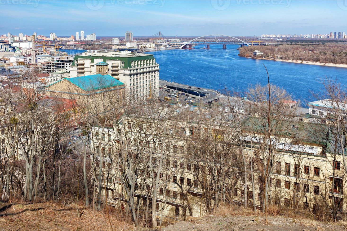 paisaje urbano de Kyiv a principios de primavera con vistas al ancho río dnipro, puentes, viejo podil en un día soleado. foto