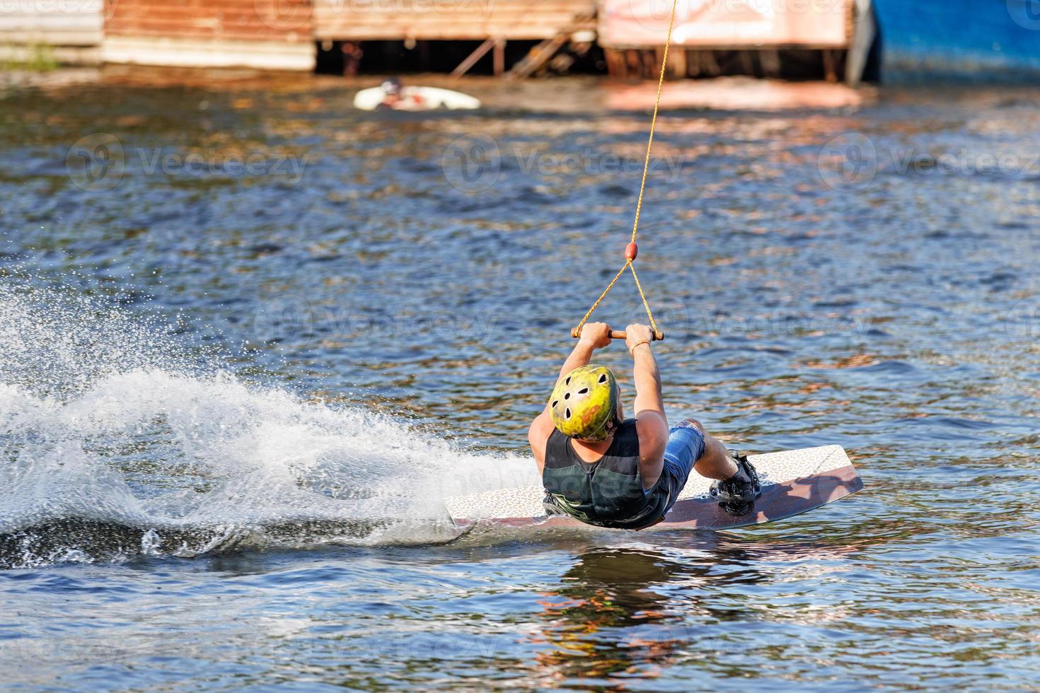 el wakeboarder entra en un giro pronunciado por encima de la superficie del agua. 19.06.1922. Kyiv Ucrania. foto