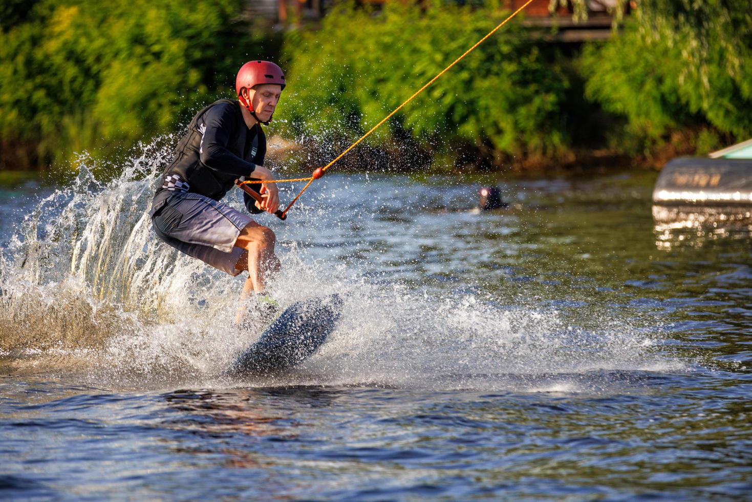 carrera de velocidad de un wakeboarder en una tabla de agua en un día de verano. salpicaduras de agua altísimas de una tabla de agua. 19.06.1922. Kyiv Ucrania. foto