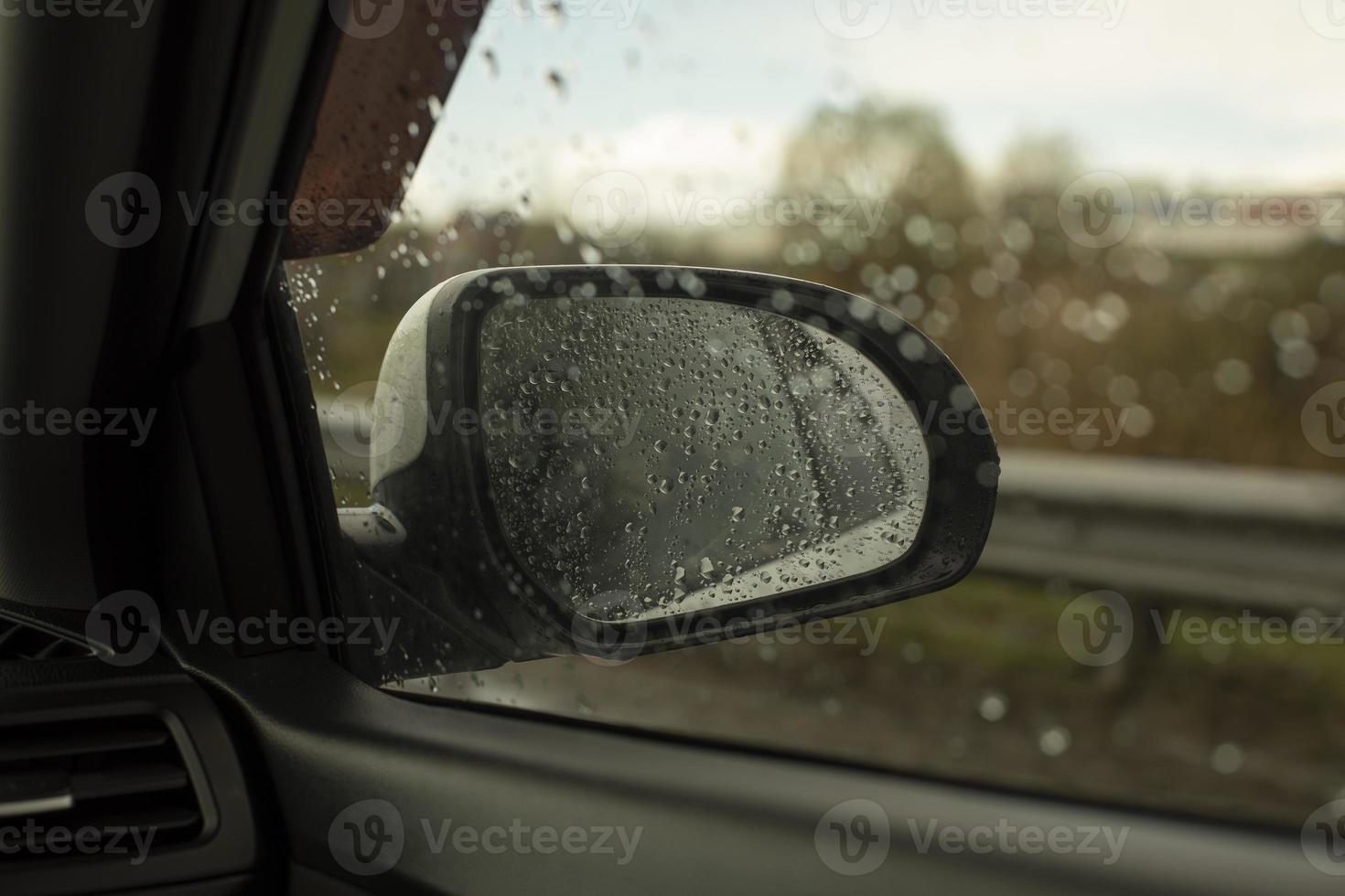 Rear-view mirror in car. Car window in rain. Transport details. photo