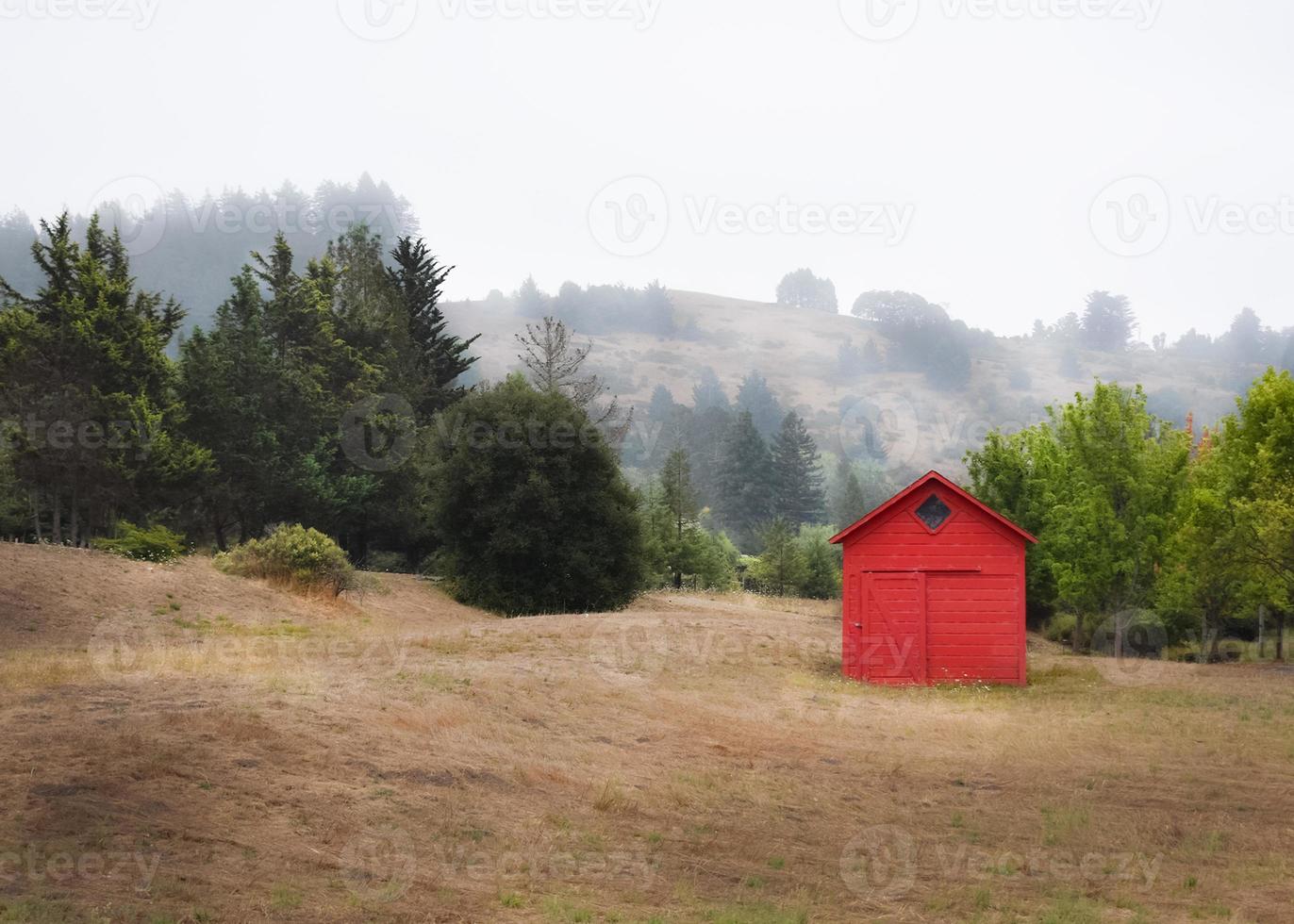 Little Red Barn in the Countryside with Foggy Hills photo
