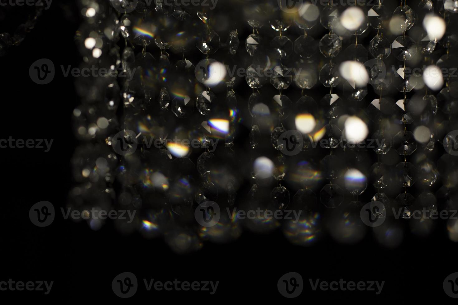 Texture of transparent glass in artificial light. Details of chandelier made of glass in dark. photo
