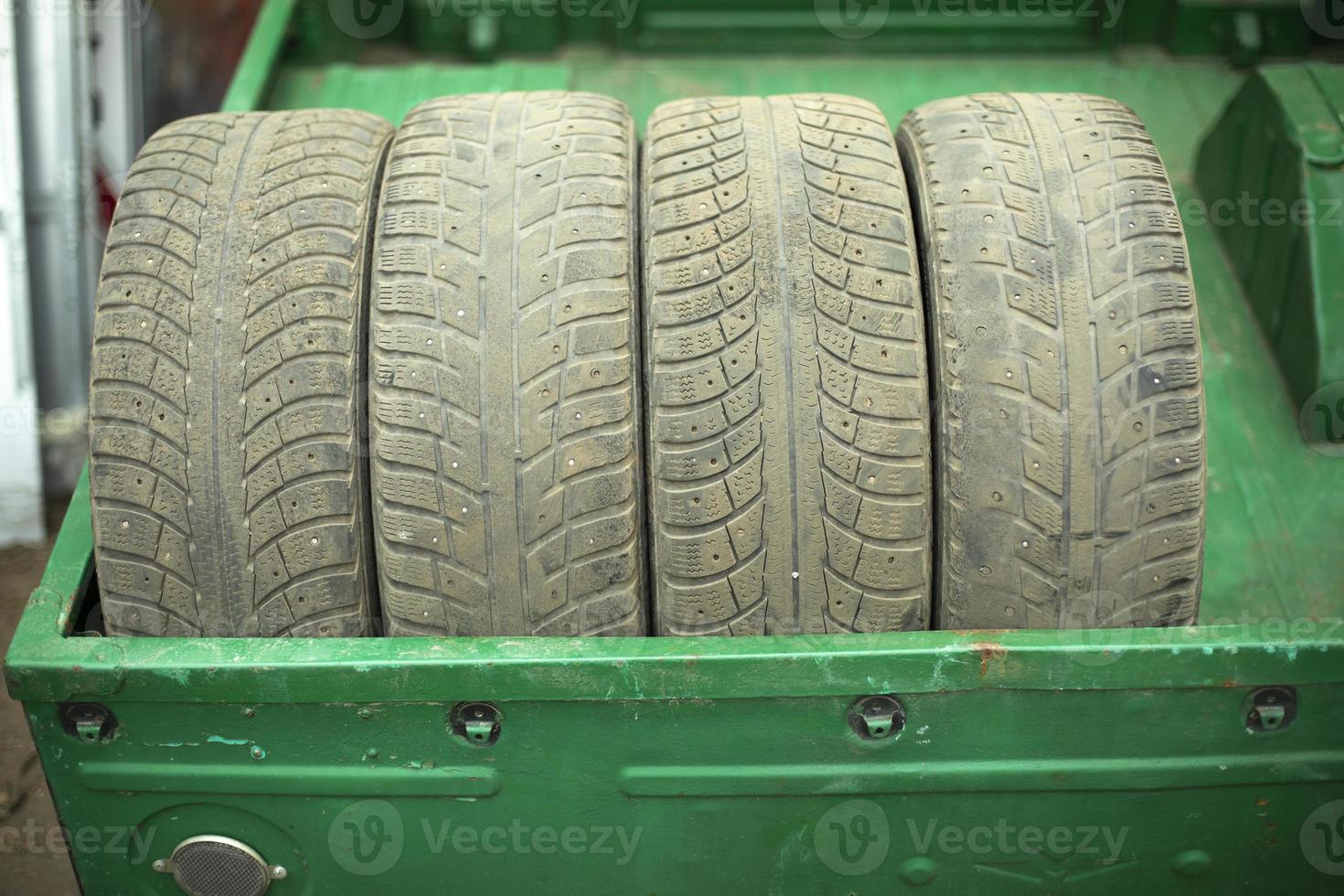 Wheels of car. Replacement of winter tires on transport. Old tires are stacked in trailer. photo