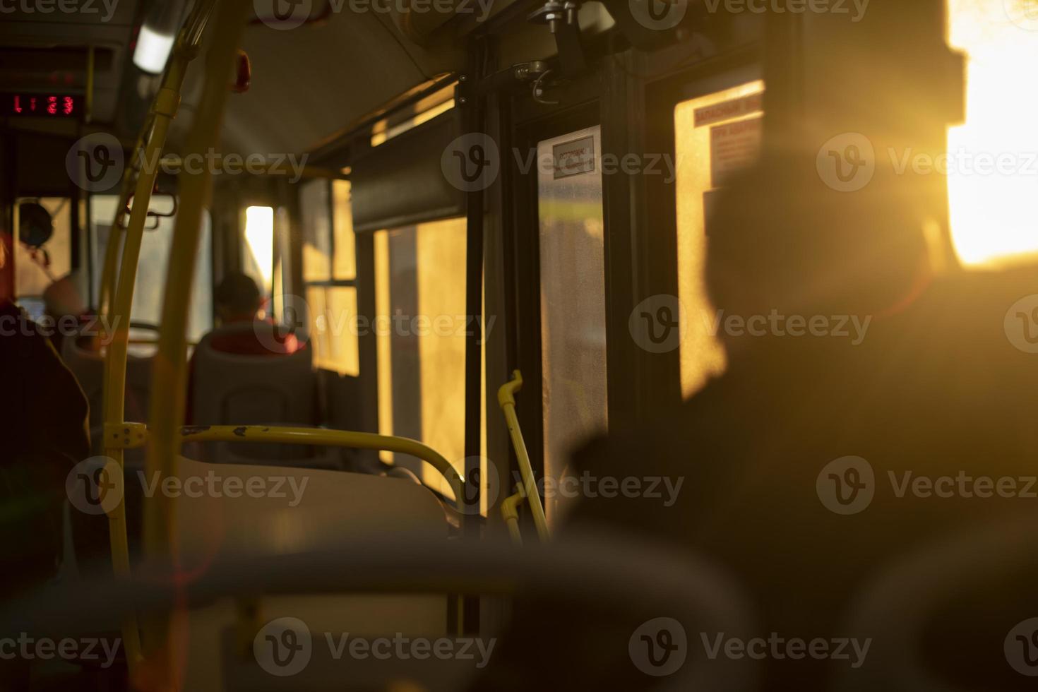 Inside bus is light of sun. People in transport. photo