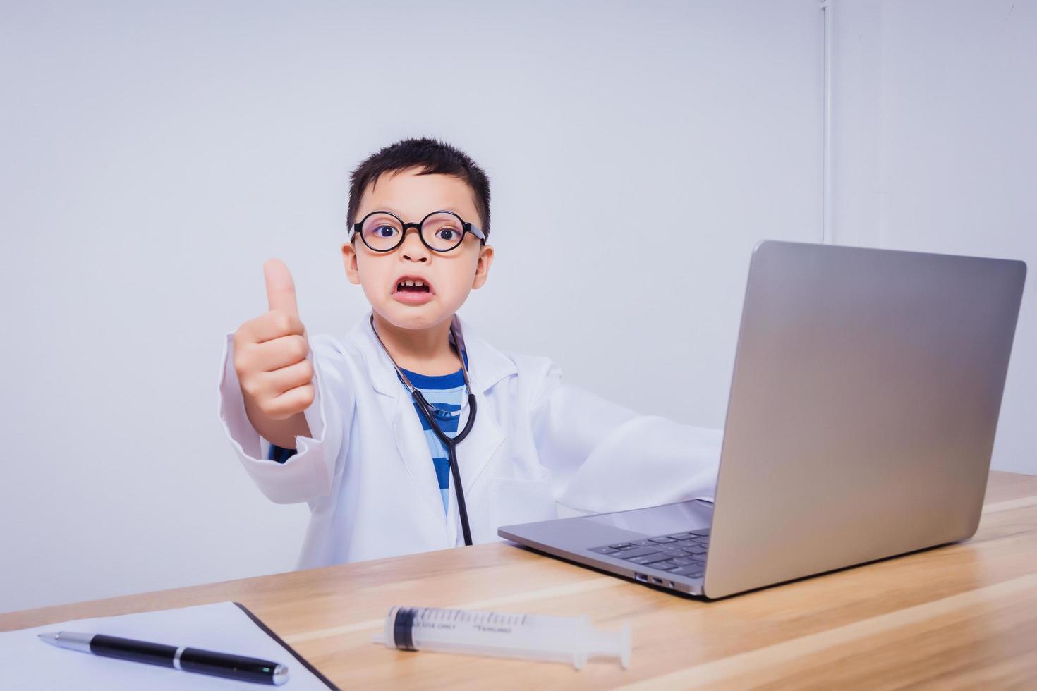 Asian boy doctor using a laptop computer photo