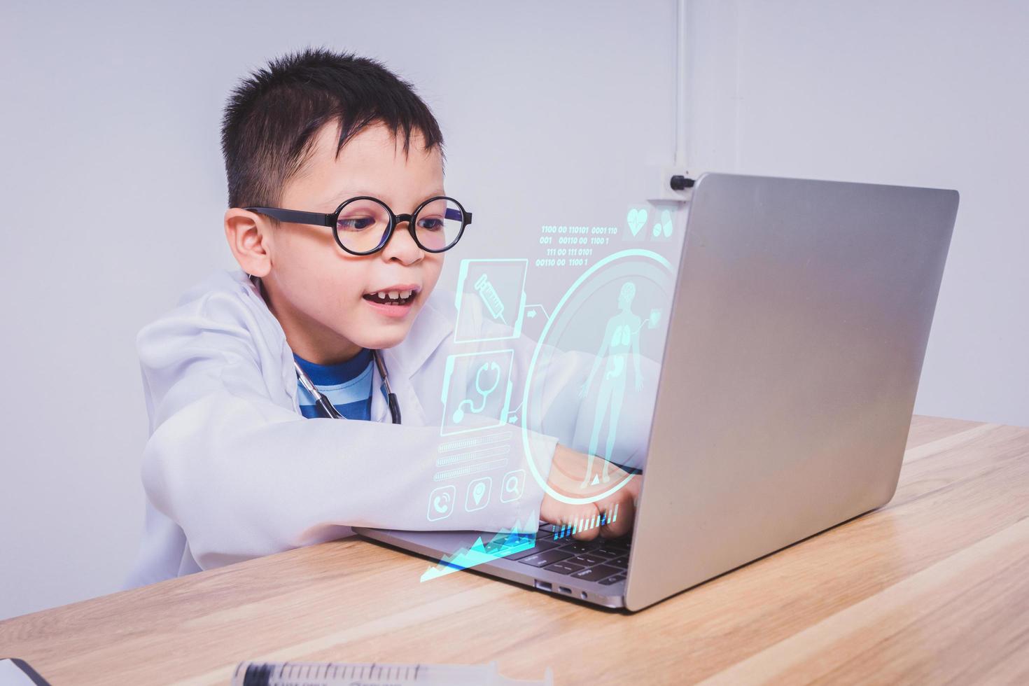 niño asiático doctor usando una computadora portátil foto