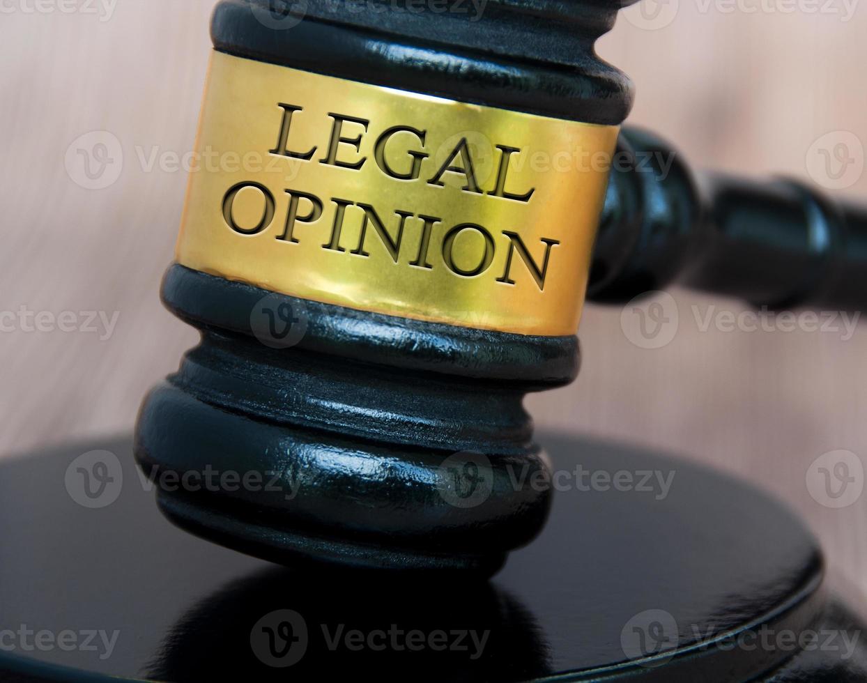 texto de opinión legal grabado en martillo de abogado con fondo de madera borroso. concepto legal y legal foto
