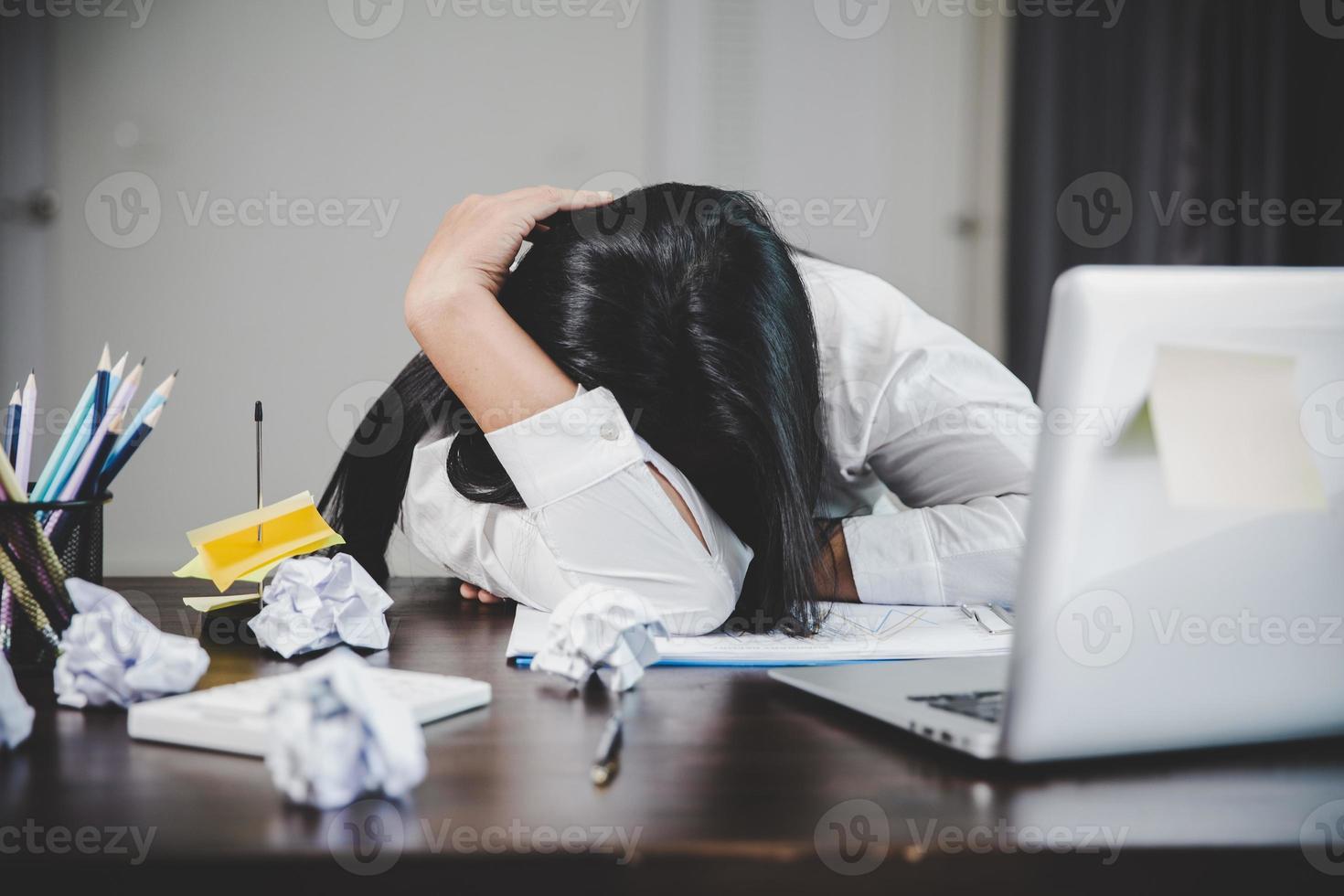 estrés mujer de negocios persona de trabajo duro, depresión en el cargo. mujer empleada cansada y ansiosa con infeliz en el trabajo problemático. joven empresaria sentada triste frente a la computadora portátil en el escritorio. foto