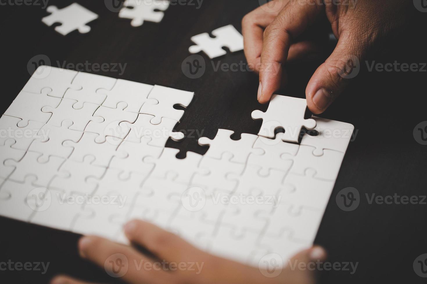 Business woman person hand with puzzle piece idea for strategy and solution. Closeup part of two white jigsaw connect together. Concept of join cooperation success teamwork-problem corporate team. photo