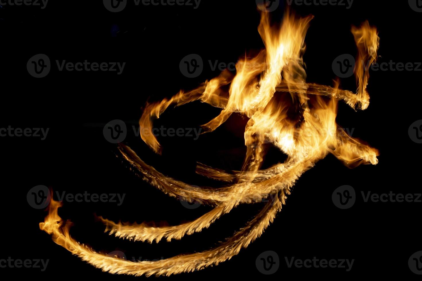 Flames in dark. Lines of fire. Fire show is shot at long shutter speed. photo