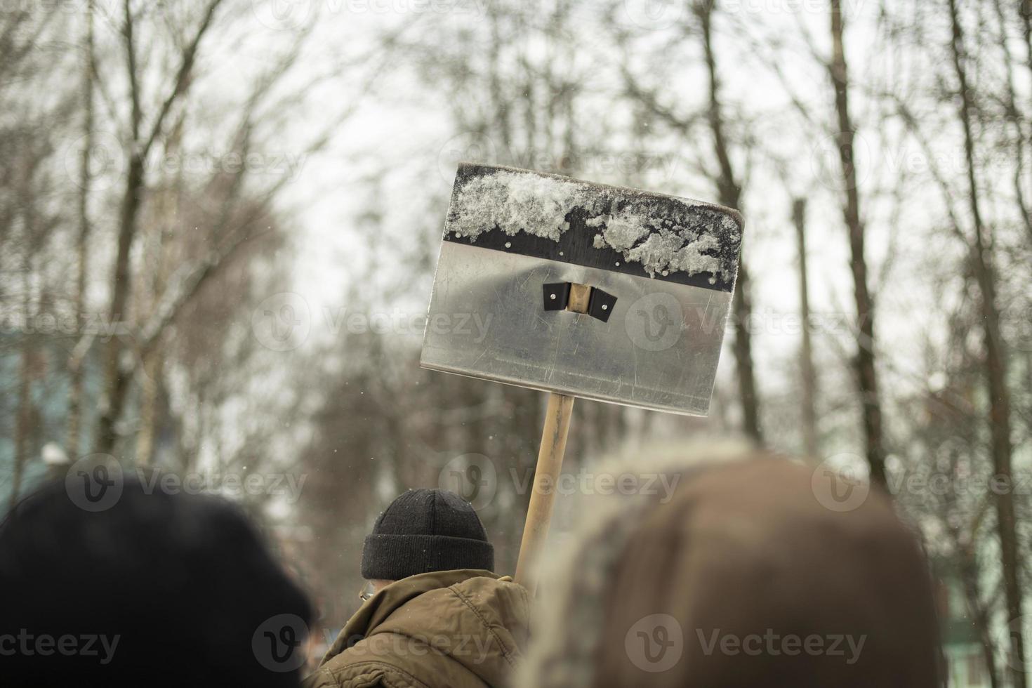 Man carries shovel on his shoulder. People go to work. photo