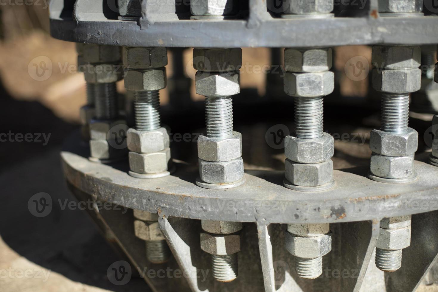 Nuts on bolts. Base of communication pole. Steel structural elements. photo