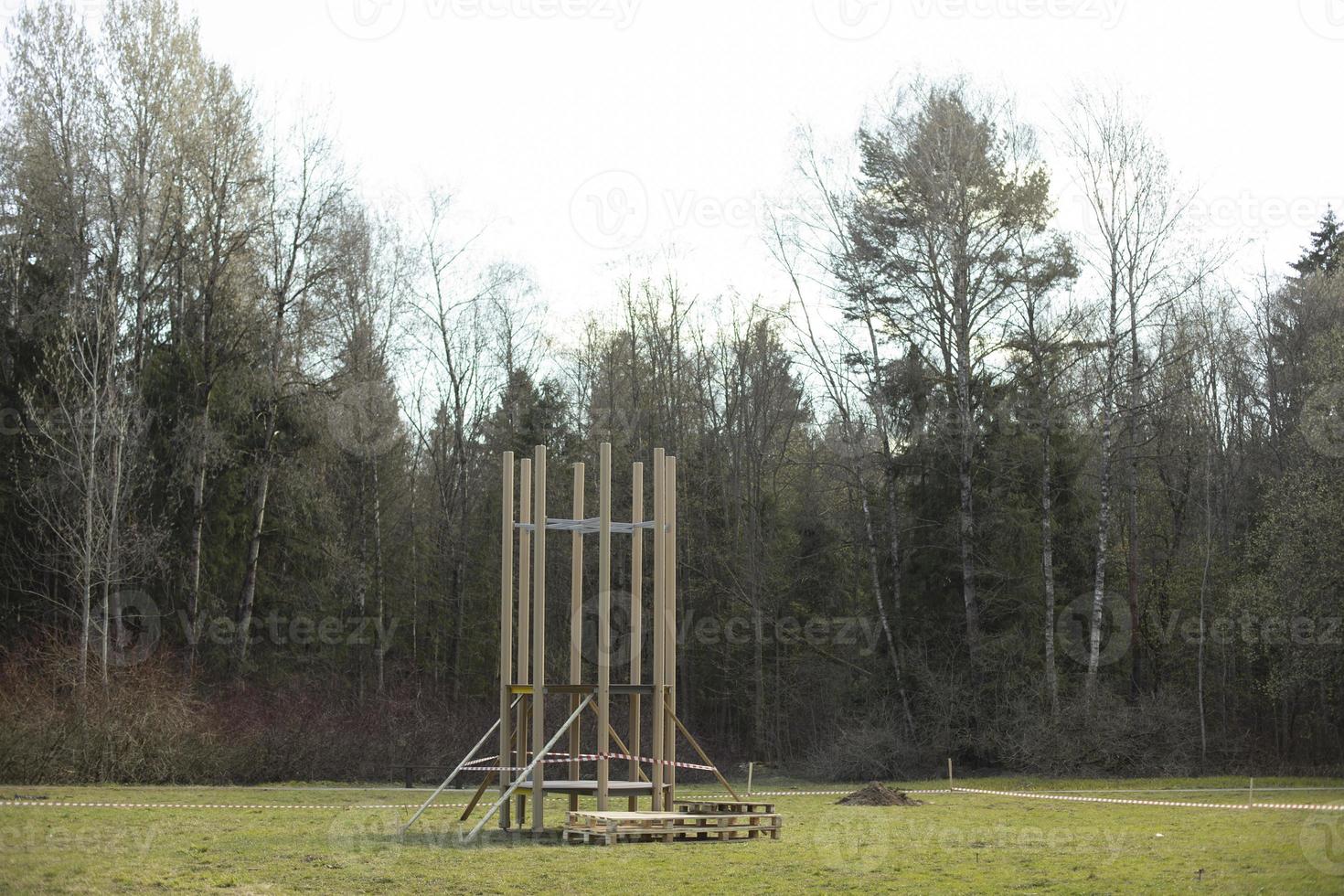 Construction in park. Construction of playground on grass. Installation of parts of structure. photo
