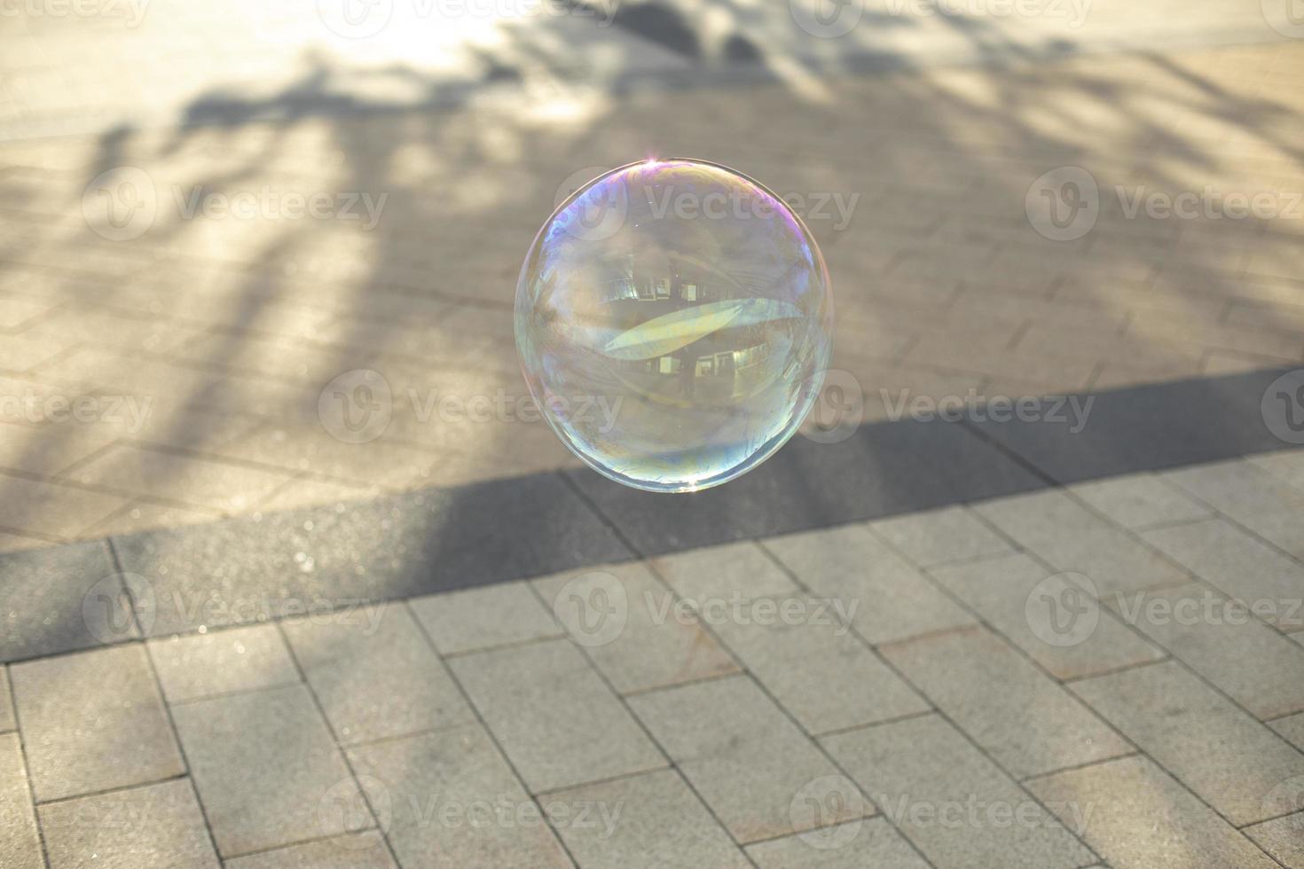 Bubble flies over road. Soap sphere. photo