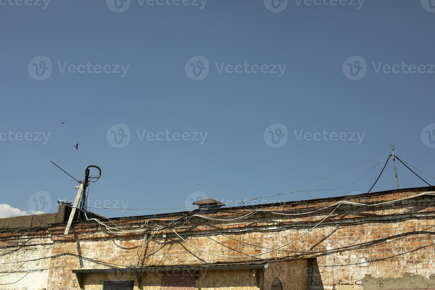 Old roof with wires. Roof of brick building. Industrial House. photo