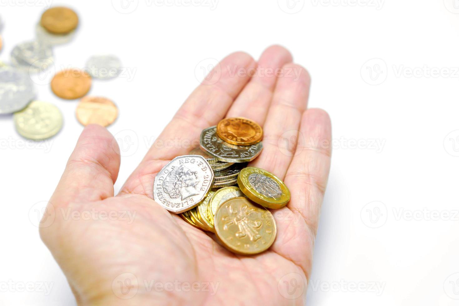 British currency coins on hand and blurry coins with isolate on white background and make with paths. photo