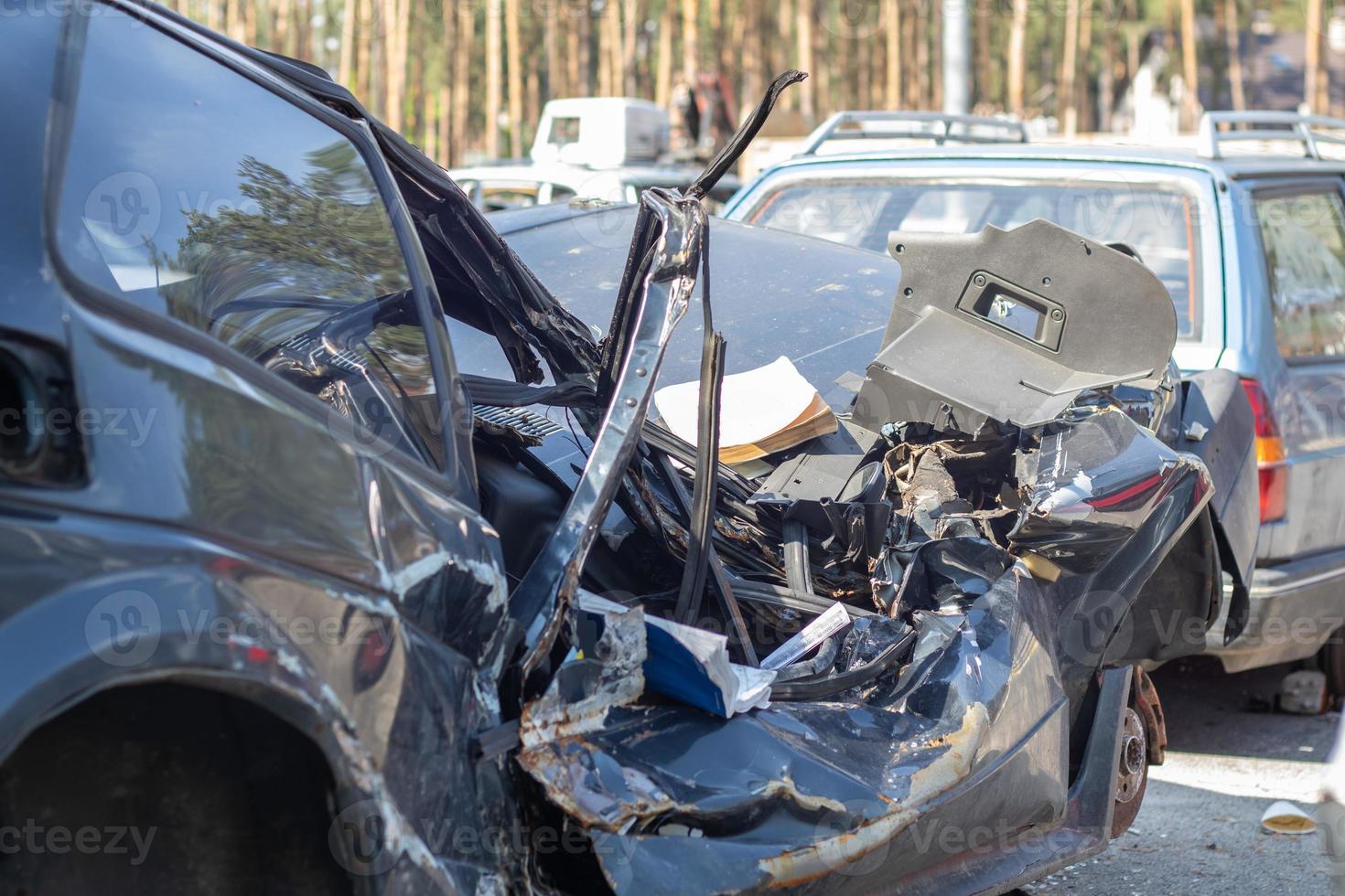 A lot of broken cars after a traffic accident in the parking lot of a repair station on the street. Car body damage workshop outdoors. Sale of insurance cars at auction. photo