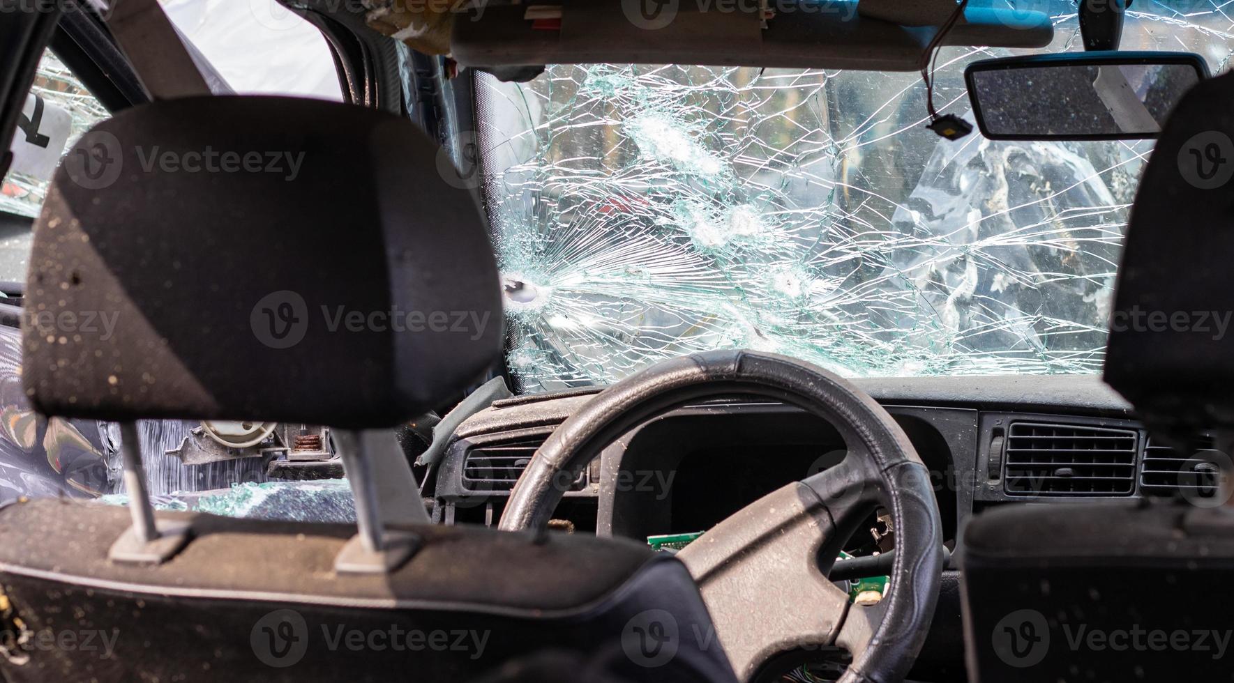 ventana de coche dañada después de un accidente. parabrisas roto como resultado de un accidente, vista interior. detalles del interior de la cabina, vista desde la cabina. movimiento seguro. parabrisas roto. grietas y daños en el vidrio. foto