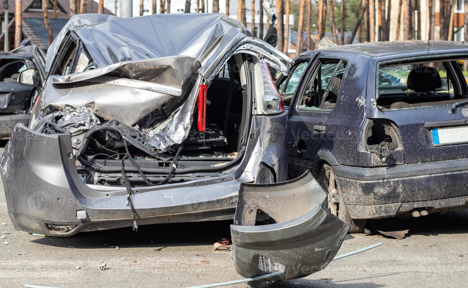 Broken car after a traffic accident in the parking lot of a repair station. Car body damage workshop outdoors. Sale of insurance cars. Accident on the street, car after a collision in the city. photo