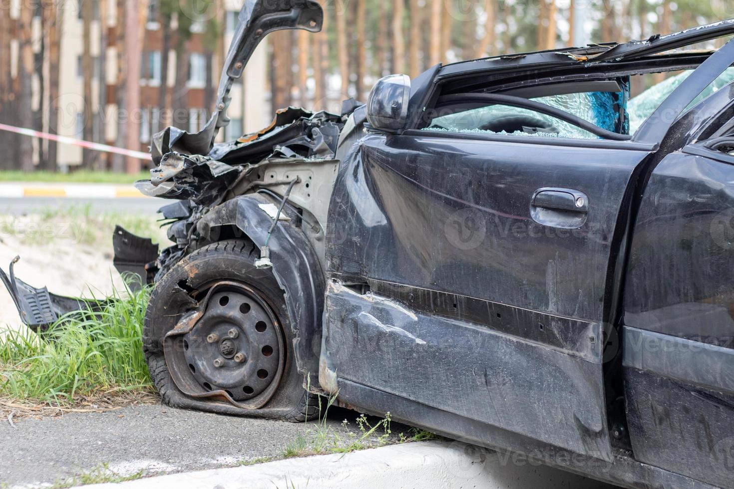 Black car after a terrible accident on the side of the road. Frontal and side impact. Life insurance. An accident without the possibility of recovery. Side view. Damage after an accident. photo