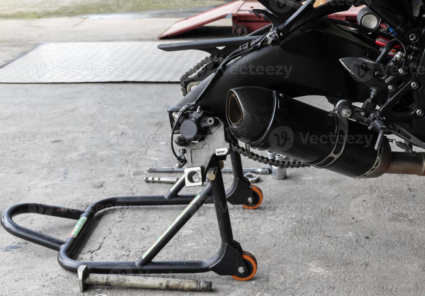 Back view motorcycle up to stand to remove wheel to change tire photo
