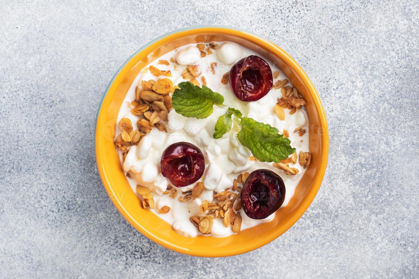 Grain curd muesli with fresh cherries on a plate. Concept healthy Breakfast with cottage cheese and berries. Copy space photo