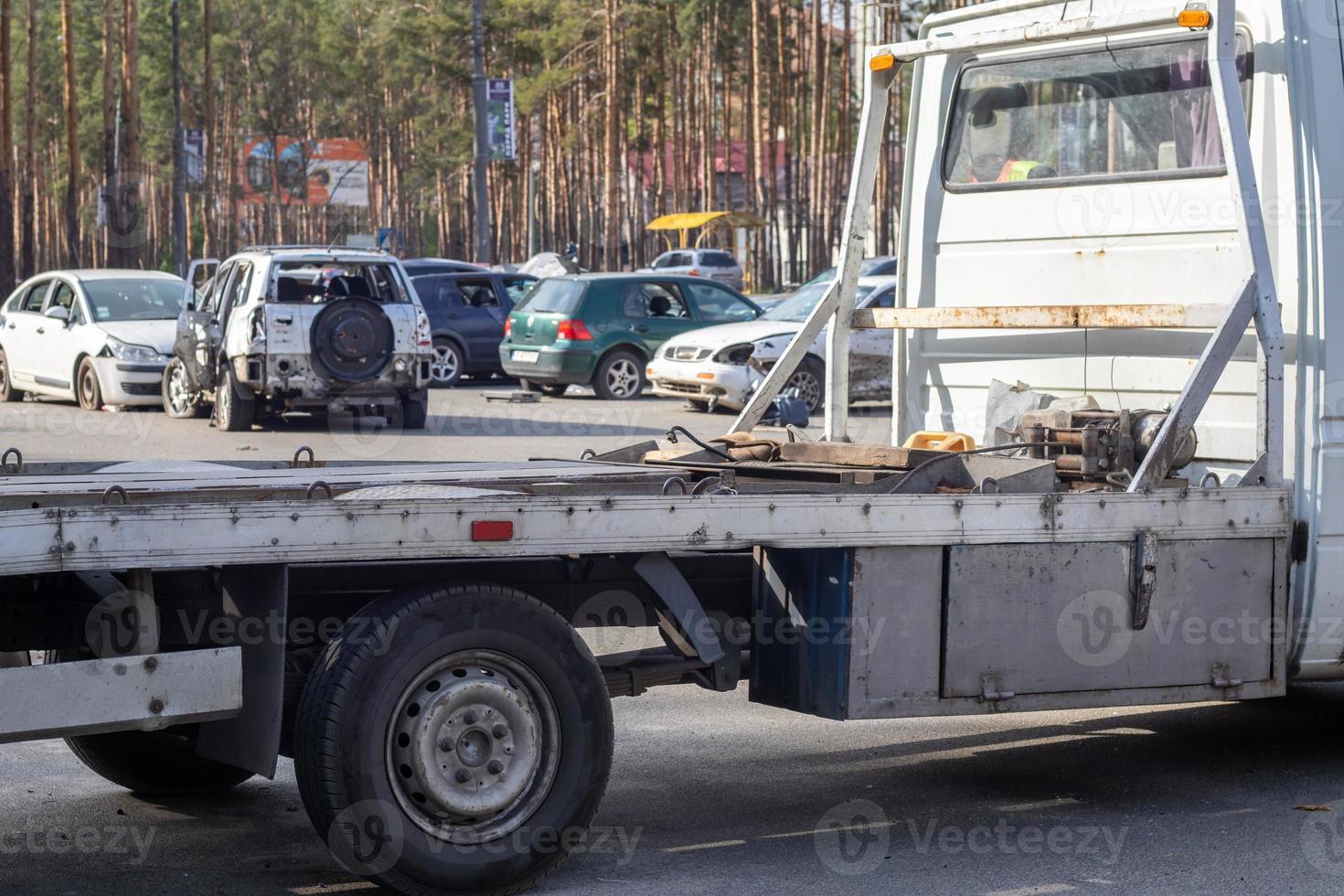 Lots of old cars ready for recycling. Car removal by tow truck. The car is getting ready to be loaded onto a tow truck. Old wrecked cars in a junkyard are waiting to be destroyed in a recycling park. photo