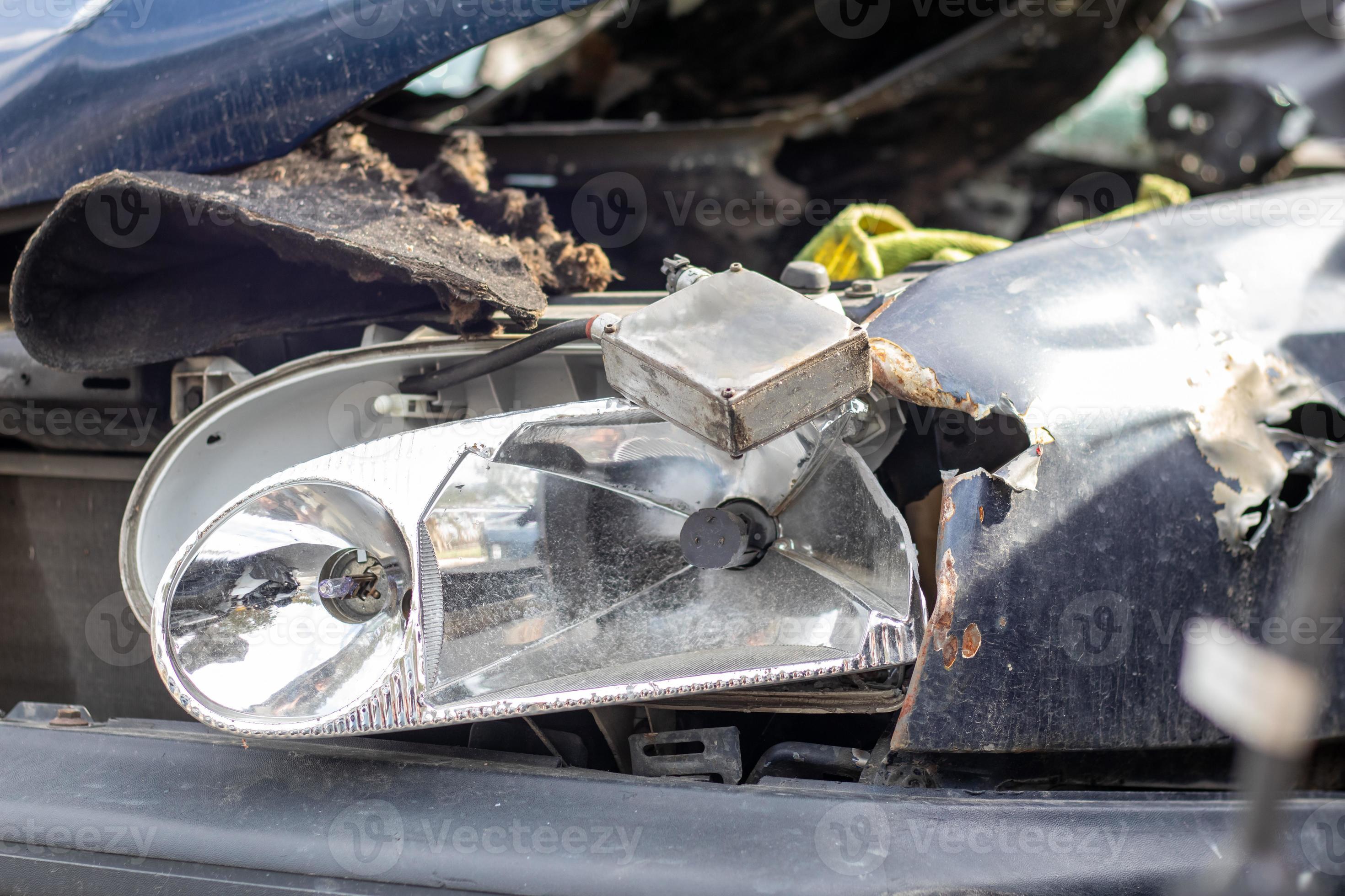 Broken headlights as a result of a collision. Broken blue car after an