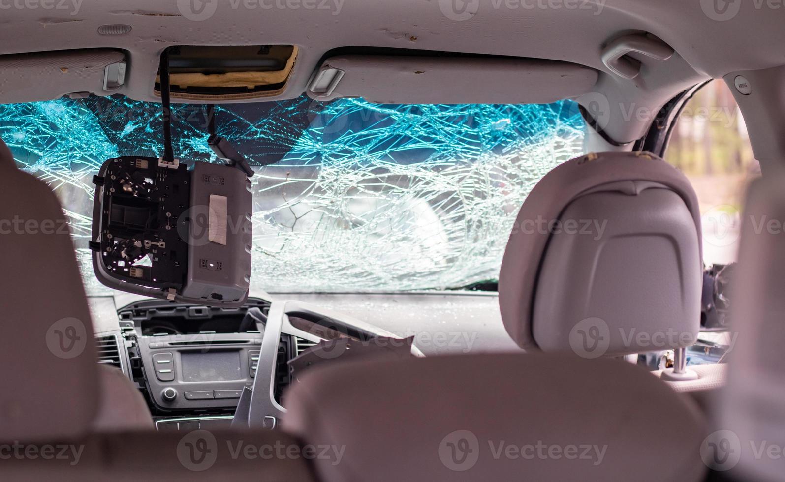 Damaged car window after an accident. Broken windshield as a result of an accident, inside view. Cabin interior details, view from the cab. Safe movement. Broken windshield. Glass crack and damage. photo
