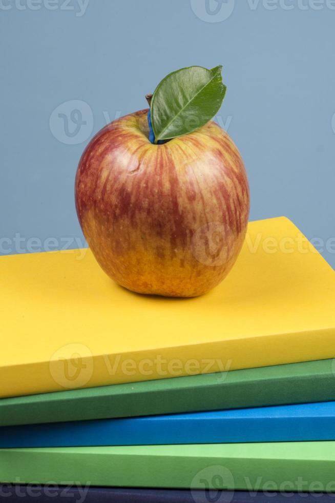 Apple fruit on top of a book stack, on the back of school classes. photo