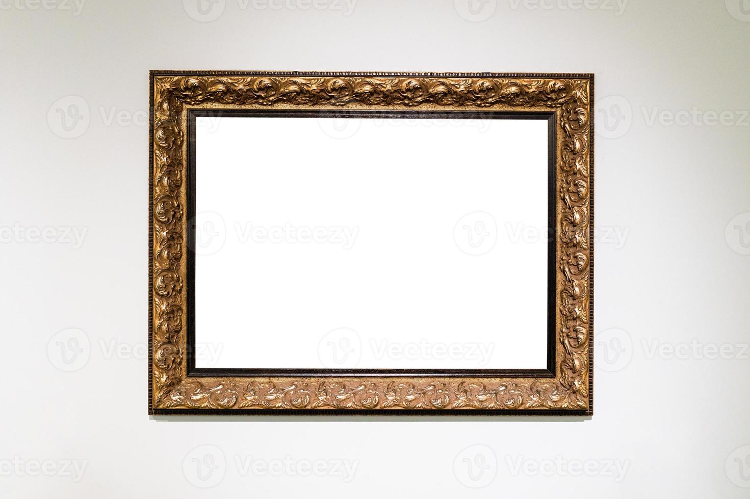 old carved wide bronze picture frame on white wall photo