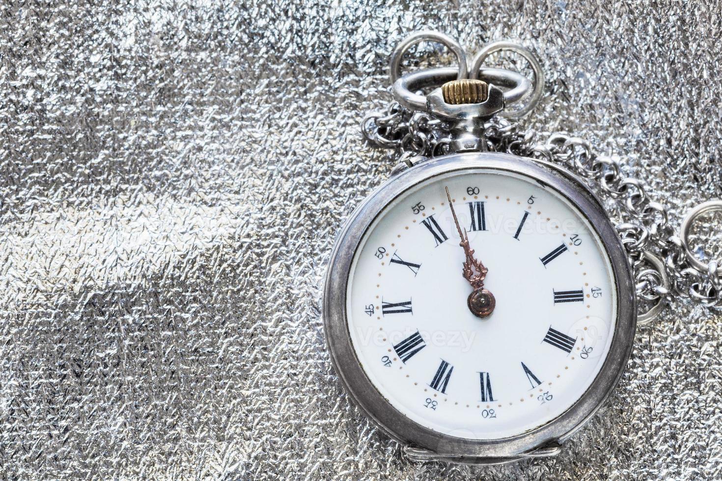 old pocket watch on silver textile background photo