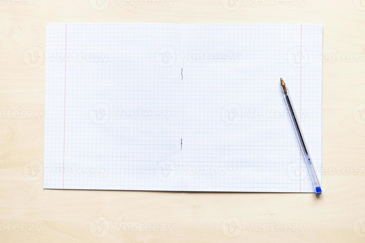 pen and open school notebook with squared sheets photo