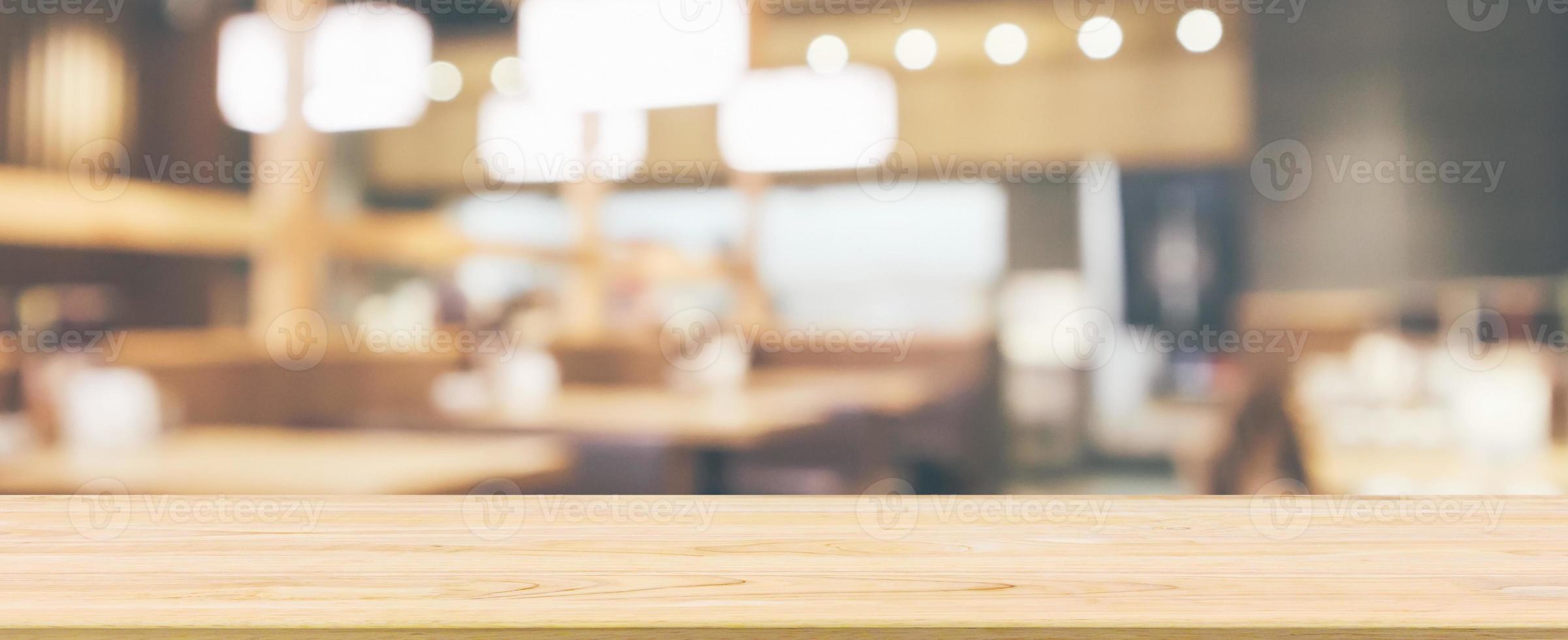Wood table top with abstract blurred cafe restaurant with bokeh lights defocused background photo