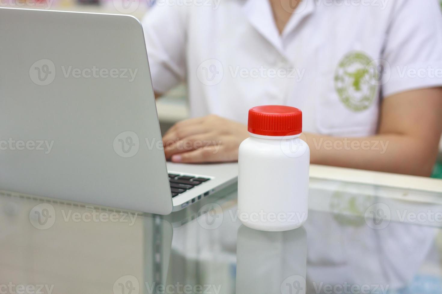 farmacéutico con computadora portátil y medicamentos en la farmacia foto