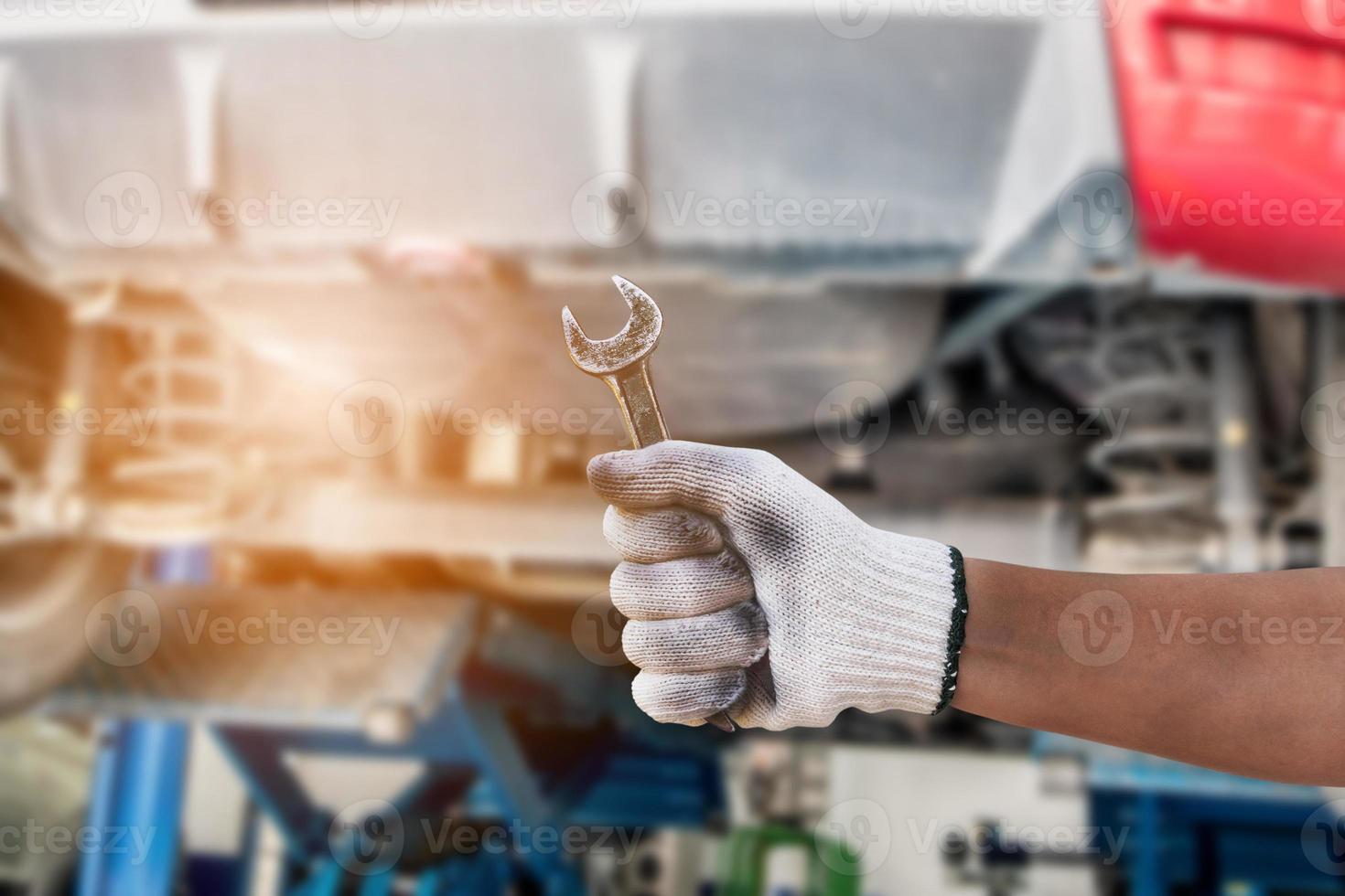 auto mechanic hand with wrench working in garage, Car repair concept photo