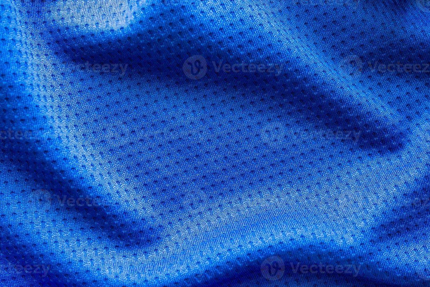 camiseta de fútbol de ropa deportiva de tela de color azul con fondo de textura de malla de aire foto