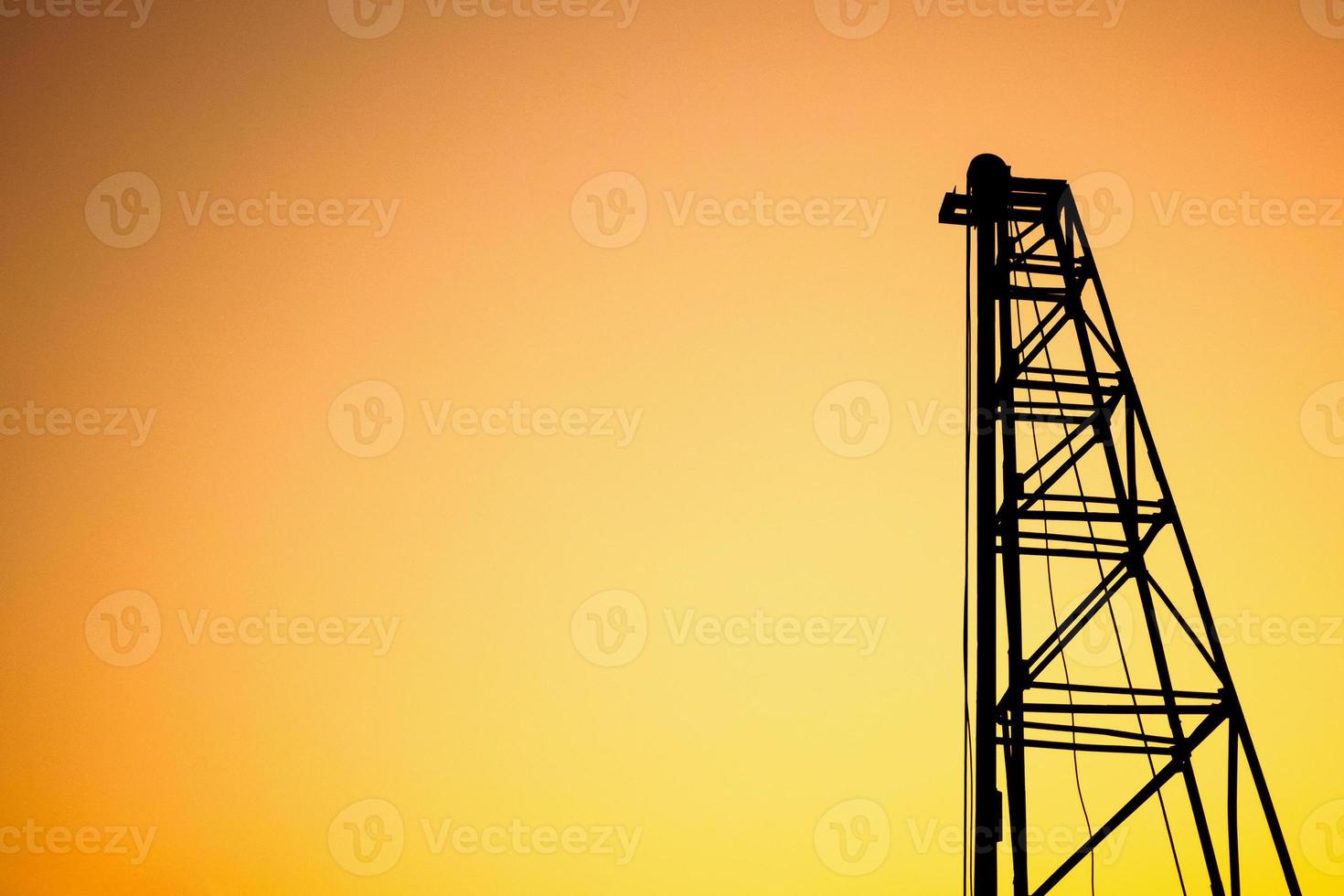 Silhouette pile driver at construction site photo