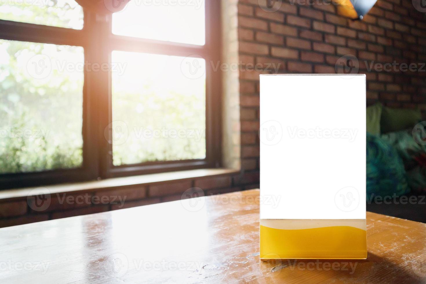 Mockup empty white label menu frame on table with cafe restaurant window interior background photo