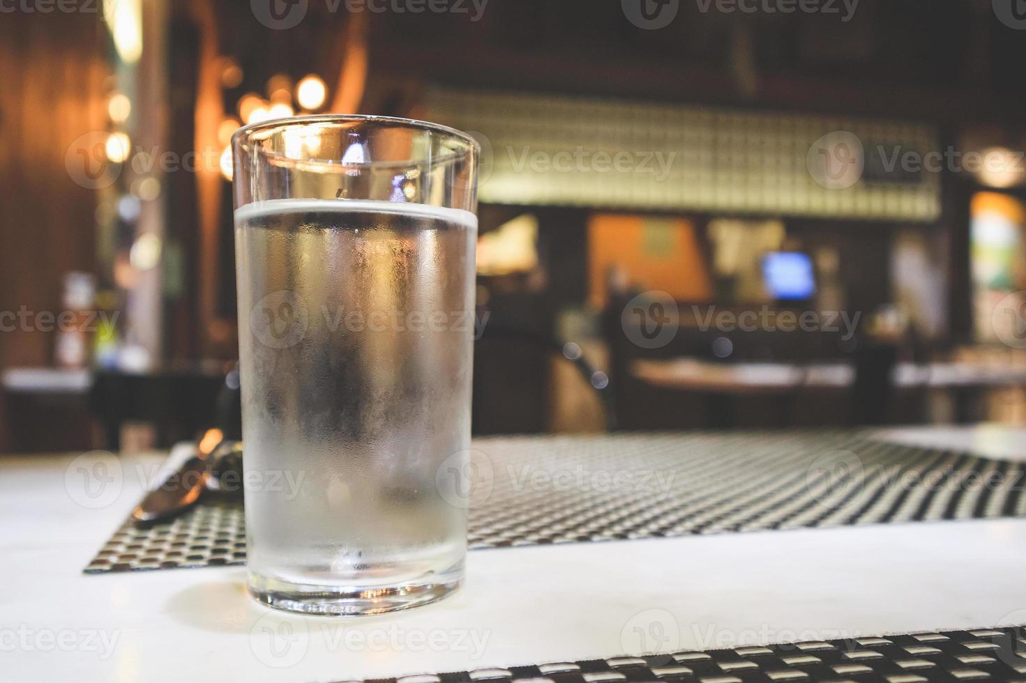Glass of water on restaurant table photo